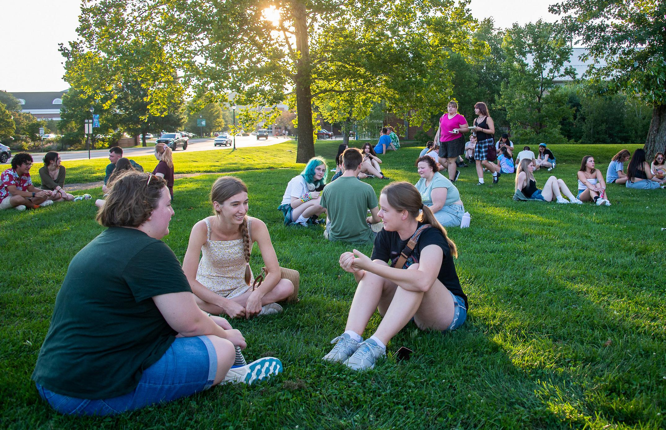 group of students sitting together on the grass